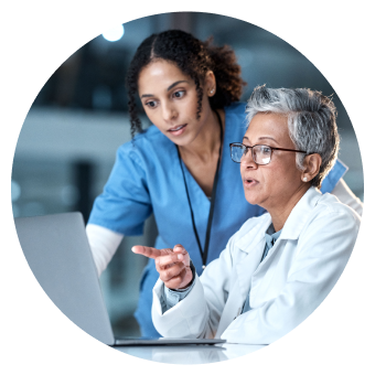 Two health care providers looking at a computer screen.