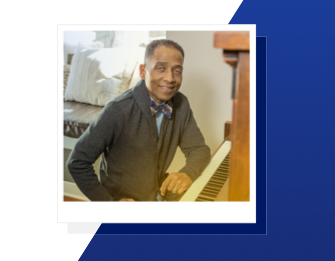 A man named Timothy sits at the piano and smiles.